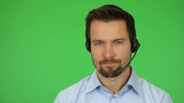 A Young Call Center Agent Shows a Thumb Down To the Camera and Shakes His Head - Green Screen