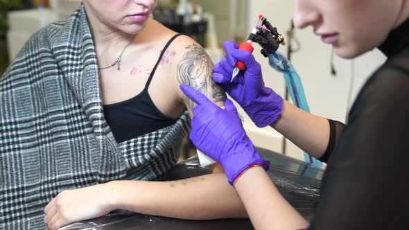 Tattoo artist tattooing an arm