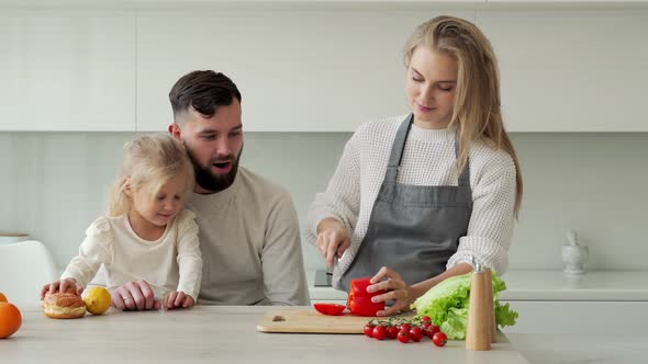 Young Family Cooks Food in the Kitchen at Home