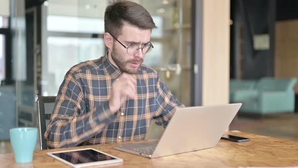 Sad Young Designer Having Shock on Laptop in Modern Office