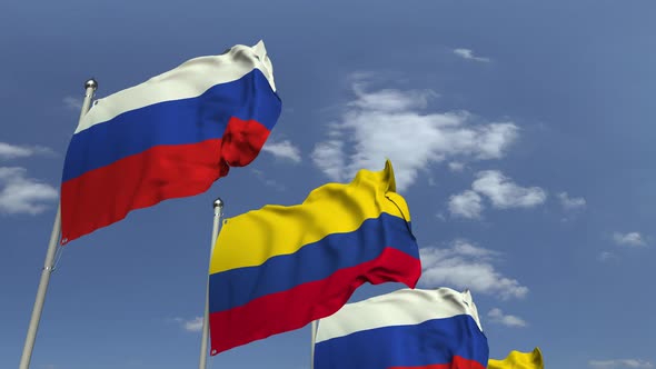 Flags of Colombia and Russia Against Blue Sky