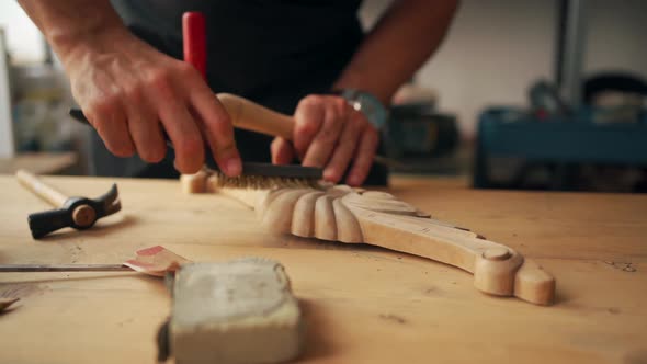 Craftsman polishing wooden detail in workshop