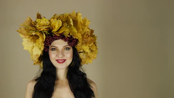 Beautiful Black Haired Girl with Bright Autumn Wreath of Leaves and Flowers in Studio Smiling and