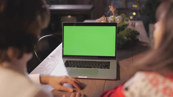 Young Couple Spending Christmas at Home Together Using Laptop with Green Screen Copy Space