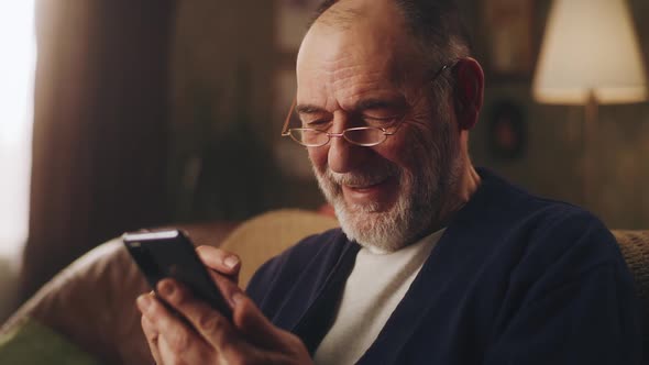 Senior Man with Smartphone Laughing