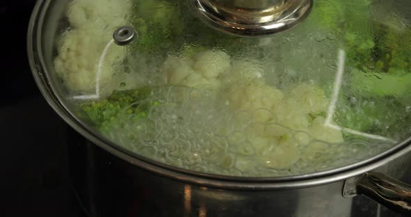 Cooking Colorful Broccoli and Cauliflower in the Pan with Boiling Water