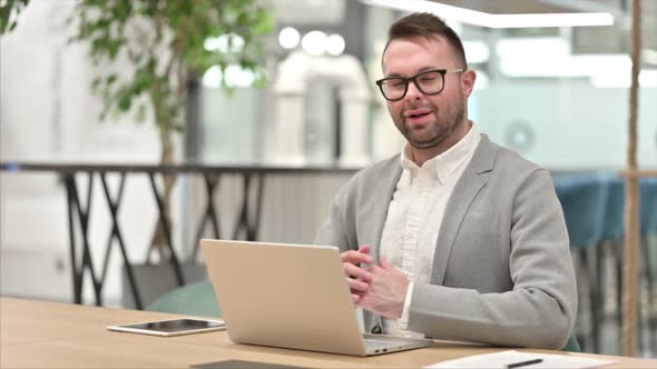 Creative Man with Laptop Smiling at Camera