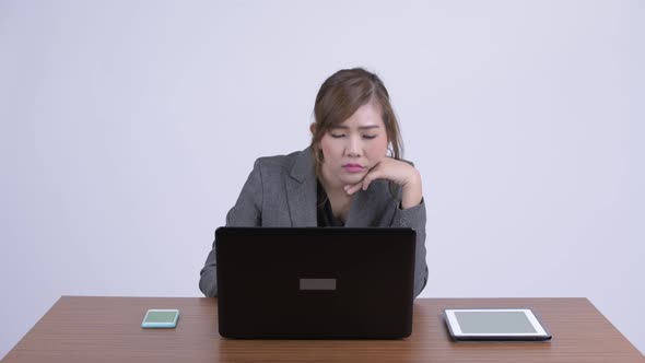 Young Stressed Asian Businesswoman Getting Bored at Work