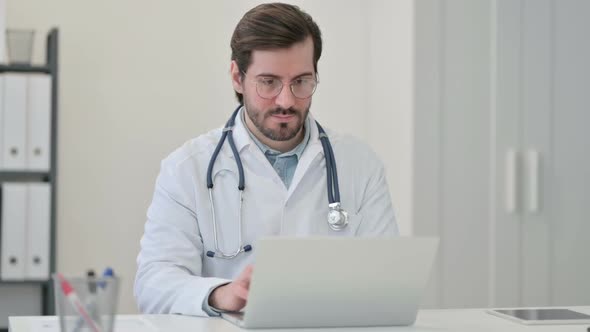 Young Male Doctor Working on Laptop