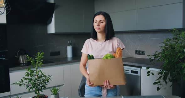 Woman Posing on Camera in Kitchen with Food Paper Bag that Bought in Supermarket