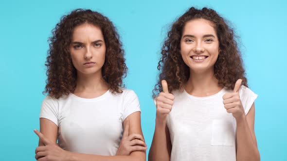 Two Beautiful Female Twins with Curly Hair Standing on Blue Background