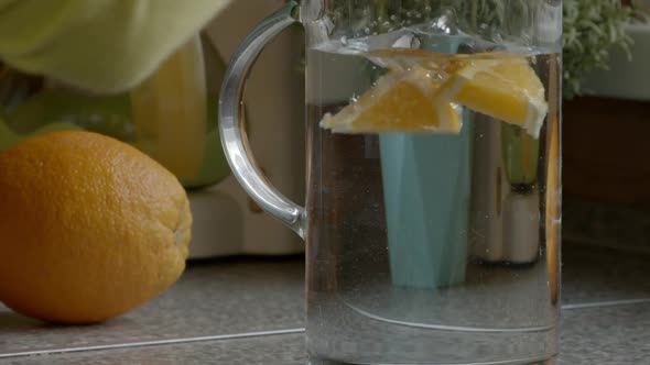 Young Caucasian Girl Is Preparing Citrus Lemonade in the Kitchen. Slow Motion