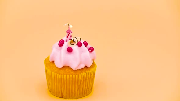 Birthday Cupcake with a Red Lit Candle, on Orange Background