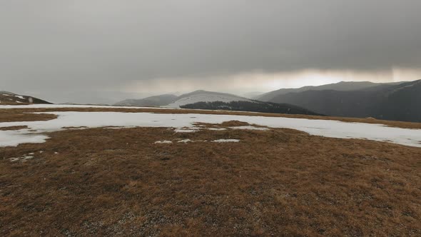 Wide-angle panning right shot of a mountain landscape with fog and snow