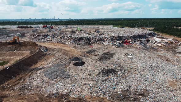 Aerial view of a large city dump. Garbage trucks unload garbage.