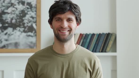 Portrait of a Happy Man in a Green Jacket Looks at the Camera and Smiles