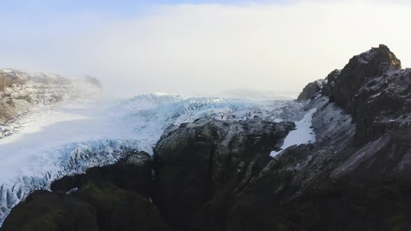 Drone Towards Black Mountain Side And Frozen Glacier Of Vatnajokull