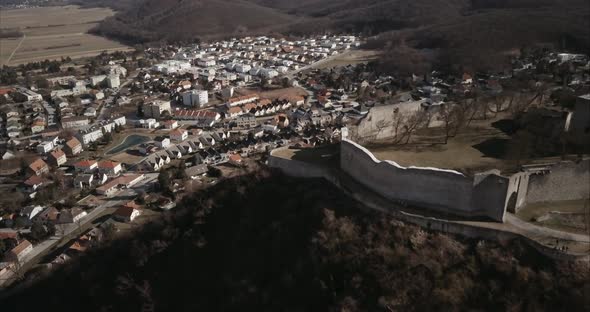 Flying above old castle on Hill in Hainburg and revealing urban area, Aerial shot, Austria