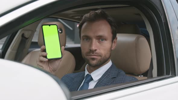 Caucasian Driver Showing Green-screened Smartphone 