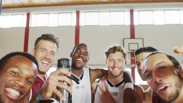 Happy basketball players standing in court