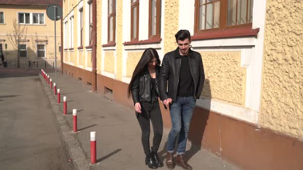 Couple walking on a street with old buildings alt