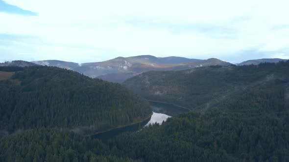 Aerial Footage Following a River through a Romanian Mountain Range then Panning to Reveal a Beautifu