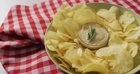 Video of crisps and cheese dip on a wooden surface