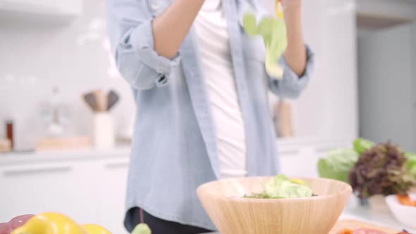 Young Asian woman making salad healthy food use organic vegetables lots.