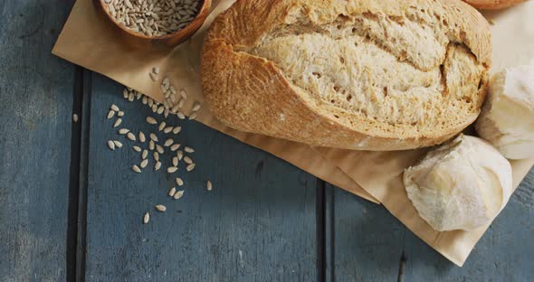 Video of rolls and bread on baking paper on wooden worktop