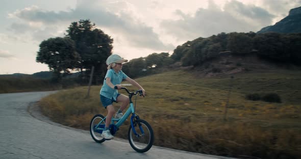 Carefree Child Ride Bicycle on Empty Mountain Road on Vacation Trip