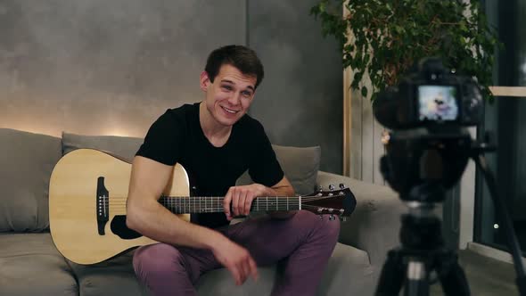 Handsome Caucasian Man in Black T Shirt Making Video Blog About Musical Instruments or Recording the