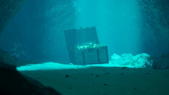 A treasure on the seabed in a secret underwater cave. Pirate chest in blue water