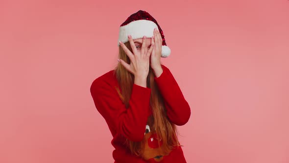 Woman in Sweater Santa Christmas Hat Fooling Around Having Closing Eyes with Hand and Spying Through