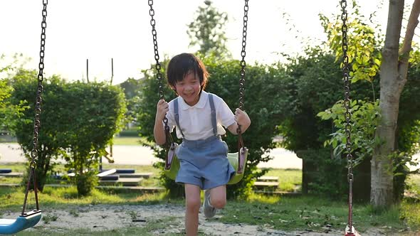 Cute Asian Child Having Fun On Swing In The Park Slow Motion