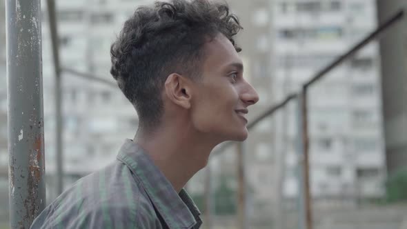 Close-up Side View of Confident Mixed-race Young Man Talking and Waving Outdoors. Portrait of