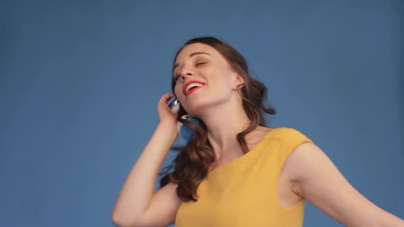 Young Girl in Yellow Shirt and Headphones Listening Music