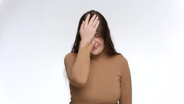 Studio Portrait of Disappointed Young Woman Making Facepalm Gesture