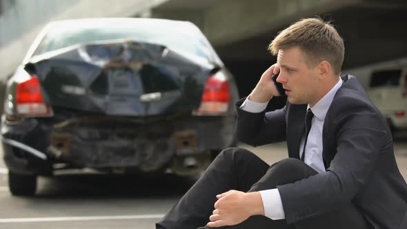 Frustrated Man Sitting on Road, Calling Police After Traffic Accident, Car Crash