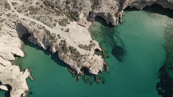 Circling over a remote beach cove in Milos Greece. Summertime holiday in Milos Greece 4k.