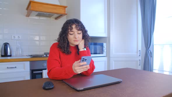 Beautiful female using modern smart phone for online communication at home during lockdown