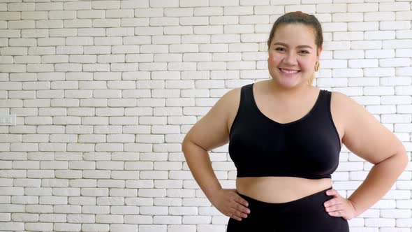 Overweight young woman in sportswear proud of her body.