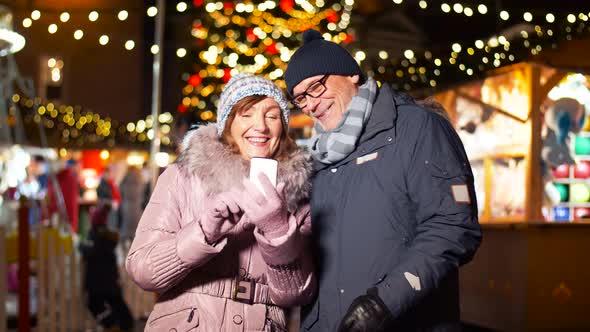 Senior Couple with Smartphone at Christmas Market 10