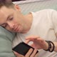 Man Looking at Photos on the Phone While Lying on the Couch - VideoHive Item for Sale