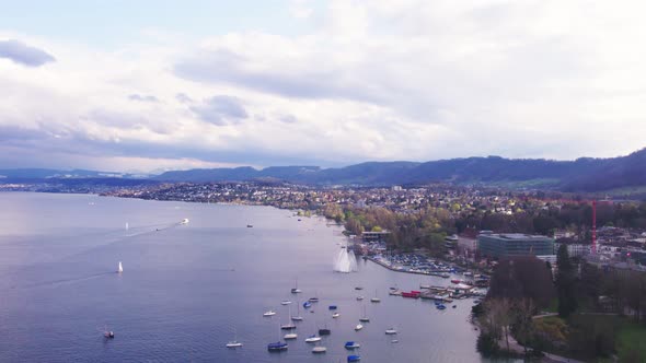 Aerial drone shot flying above Lake Zurich, Switzerland in sunny day.