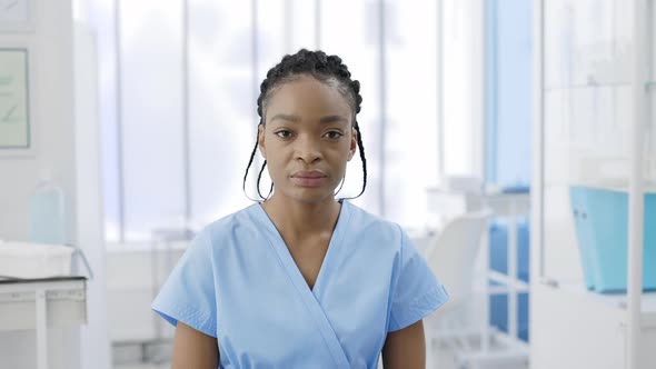 Crop View of Serious Afro  American Female Doctor Raising Head and Looking to Camera