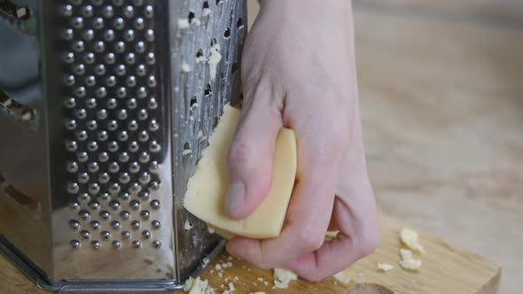 Grating cheese for bakery.