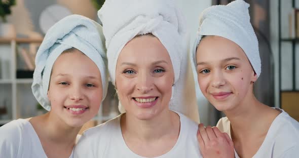 Happy Friendly Mother and Her Two Teen Daughters in Terry Towels Posing on Camera