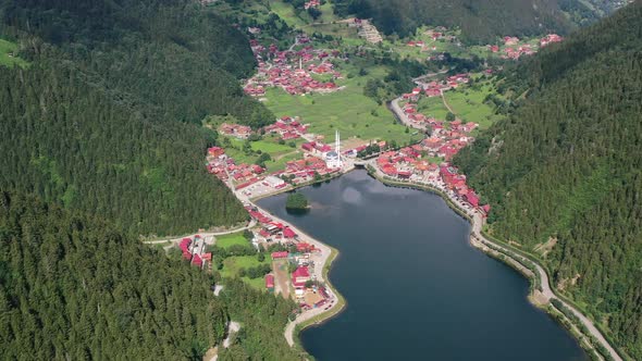 aerial top down view of a mountain village full of homes with red roofs surrounded by mountains and