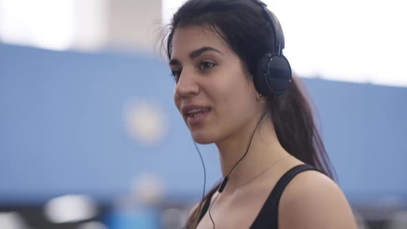 Closeup Portrait of Charming Beautiful Middle Eastern Sportswoman Enjoying Music in Headphones