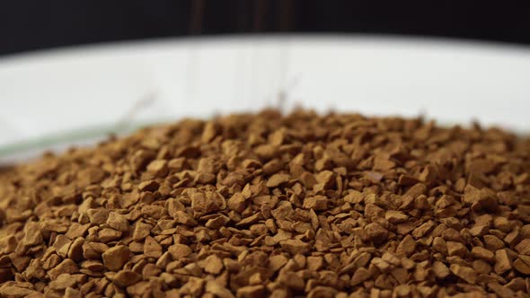 Granules of Instant Coffee Sprinkled on a Plate Closeup Spinning As a Backdground for a Coffee Shop